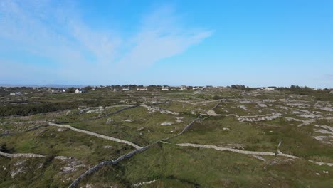 Bauernhäuser-In-Connemara-In-Der-Nähe-Von-Coral-Strand-Beach-Mit-Feldern,-Die-Durch-Mauern-Aus-Felsen-Unter-Dem-Strahlend-Blauen-Himmel-In-Irland-Getrennt-Sind