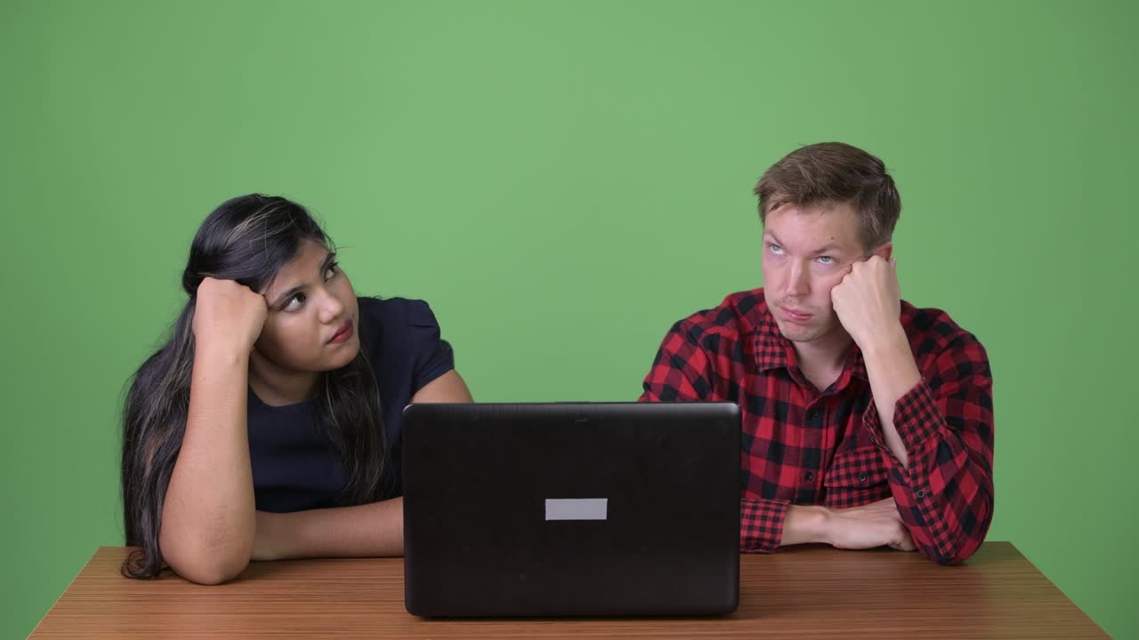 joven pareja de negocios multiétnica juntos contra un fondo verde