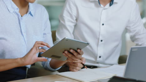 hermosa mujer de negocios líder de equipo entrenando pasante asiático usando computadora tablet compartiendo ideas colegas trabajando juntos en la oficina