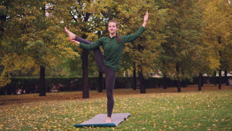woman practicing yoga in an autumn park