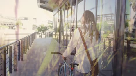 animation of grass over biracial man walking with bike