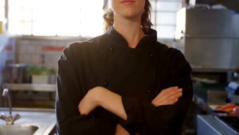 chef femenino de pie en la cocina comercial 4k