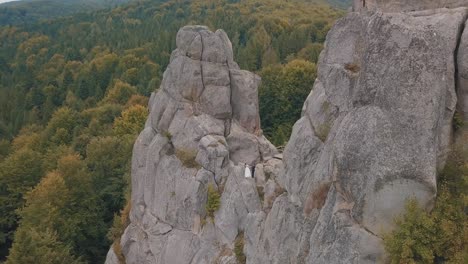 Newlyweds-stand-on-a-high-slope-of-the-mountain.-Groom-and-bride.-Aerial-view