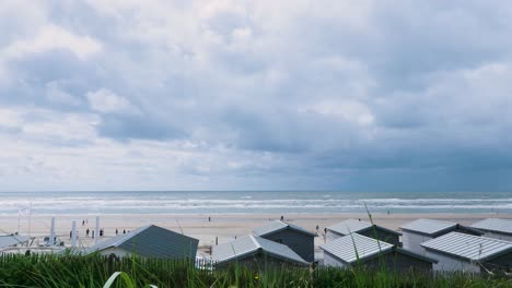 beach scene with beach huts and cloudy sky