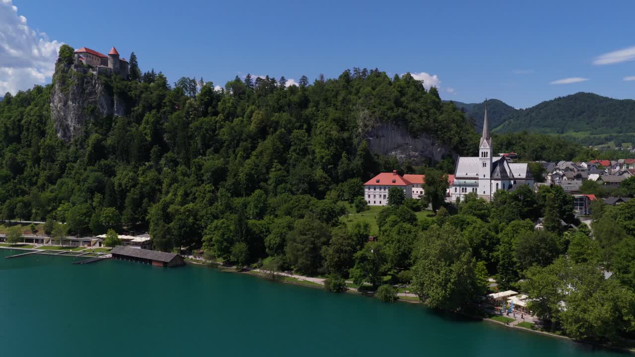 Ampia ripresa aerea che mostra il Castello di Bled, la chiesa sull'isola e il vicino villaggio alpino.