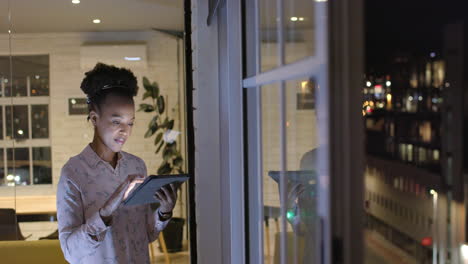 African-American-woman-reviews-data-on-a-tablet-at-night-in-a-business-office