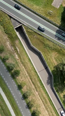 aerial view of highway intersection with green spaces and pedestrian bridge