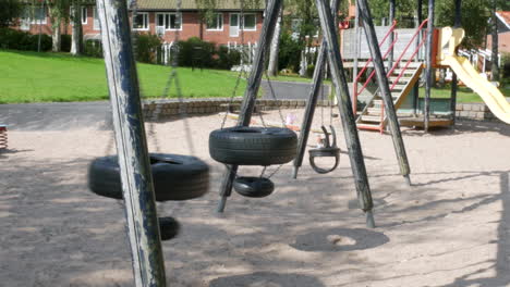 un columpio vacío hecho de neumáticos de automóviles usados balanceándose en un patio de recreo en la ciudad de partille fuera de gotemburgo, suecia
