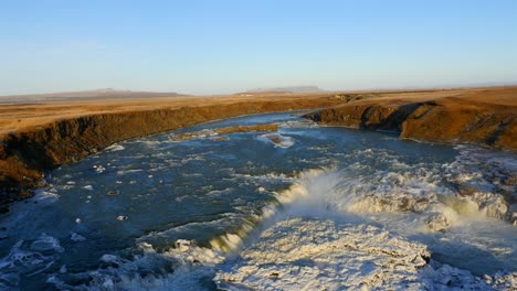 vista aérea de la cascada congelada de urriðafoss en islandia con el río salvaje