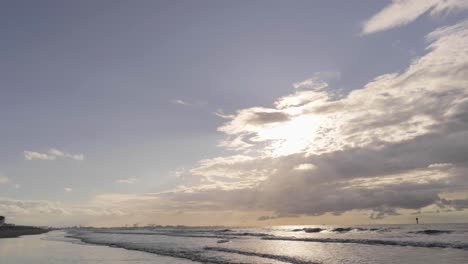 Helles-Sonnenlicht-Hinter-Den-Weißen-Wolken-über-Der-Nordsee-Mit-Wellen,-Die-An-Der-Küste-In-Knokke,-Belgien,-Plätschern