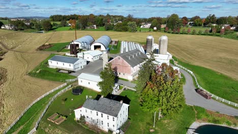 pennsylvania farm in autumn: white farmhouse, barns, silos, and harvested fields