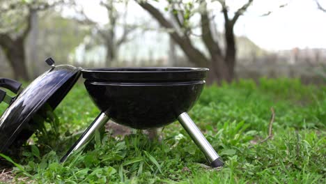 barbecue grill stands in a meadow among the green grass. picnic in nature