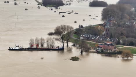 aerial orbiting view of a shipped beached along the waal river next to the town of gorinchem after the flood waters have inundated much of the surrounding countryside