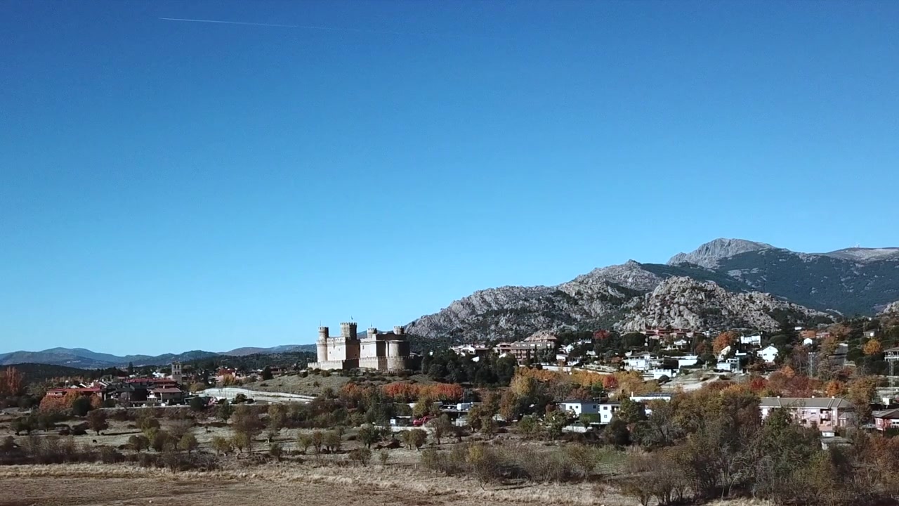 Filmato aereo del villaggio di Manzanares el Real e del castello medievale nella regione di Madrid, Spagna. Il castello storico si erge contro le montagne della Sierra de Guadarrama con il bacino di Santillana.
