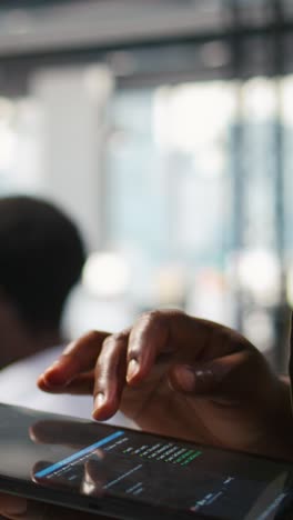 vertical video close up of engineer using tablet to write code, developing machine learning api