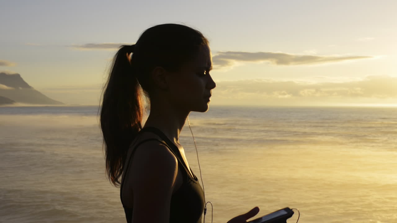 Mixed race woman runner running on beach road