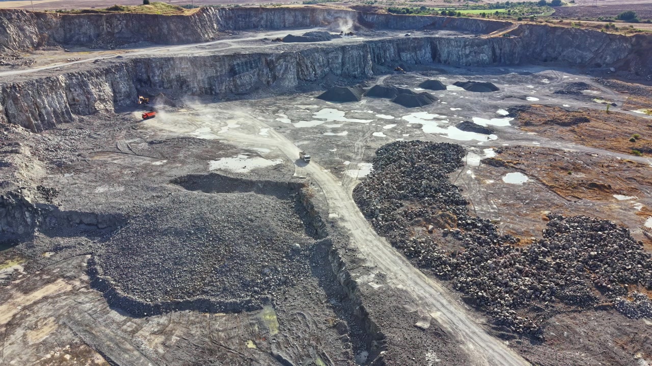 Granite quarry located in a rural area with machinery and rock piles visible during daytime