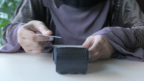 woman using credit card at point of sale