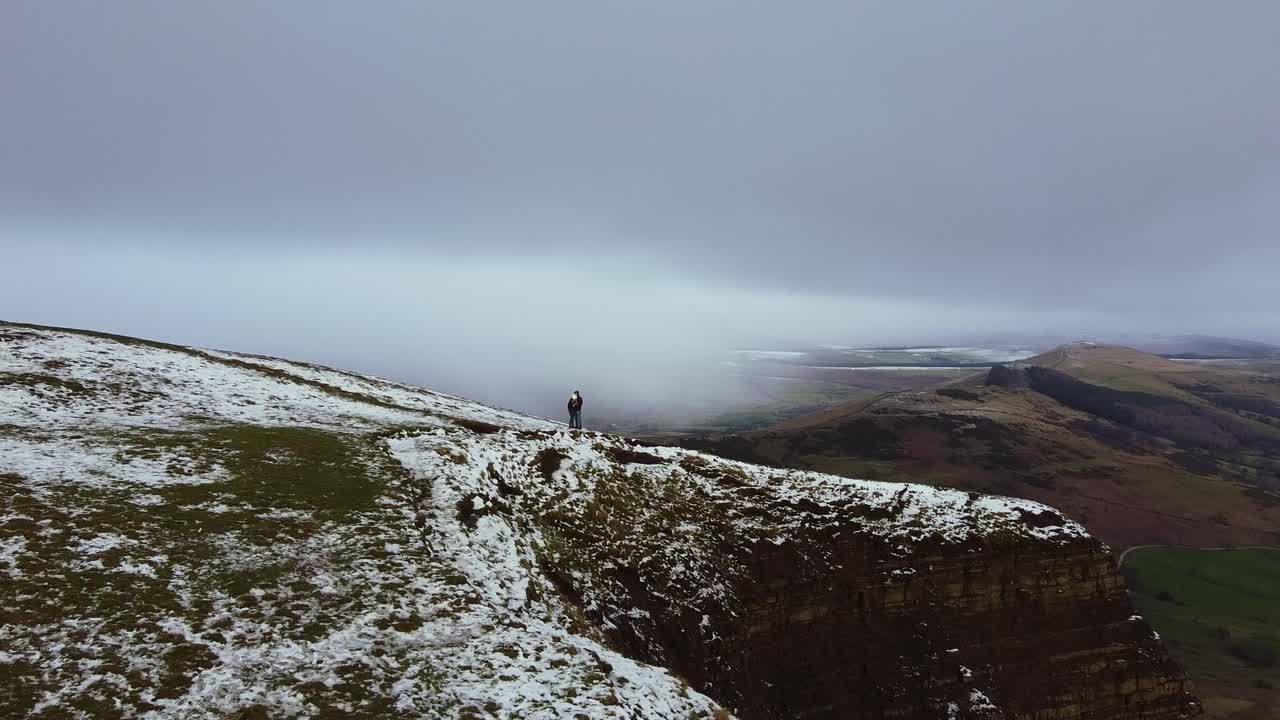 Luftfoto af Mam Tor i Peak District, England, par på toppen om vinteren