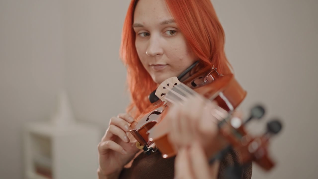 White redhead practicing violin fingering in studio, close coaching moment, teacher hand adjusting finger placement, focused gaze, soft breath, intimate lesson atmosphere, tone shaping and intonation