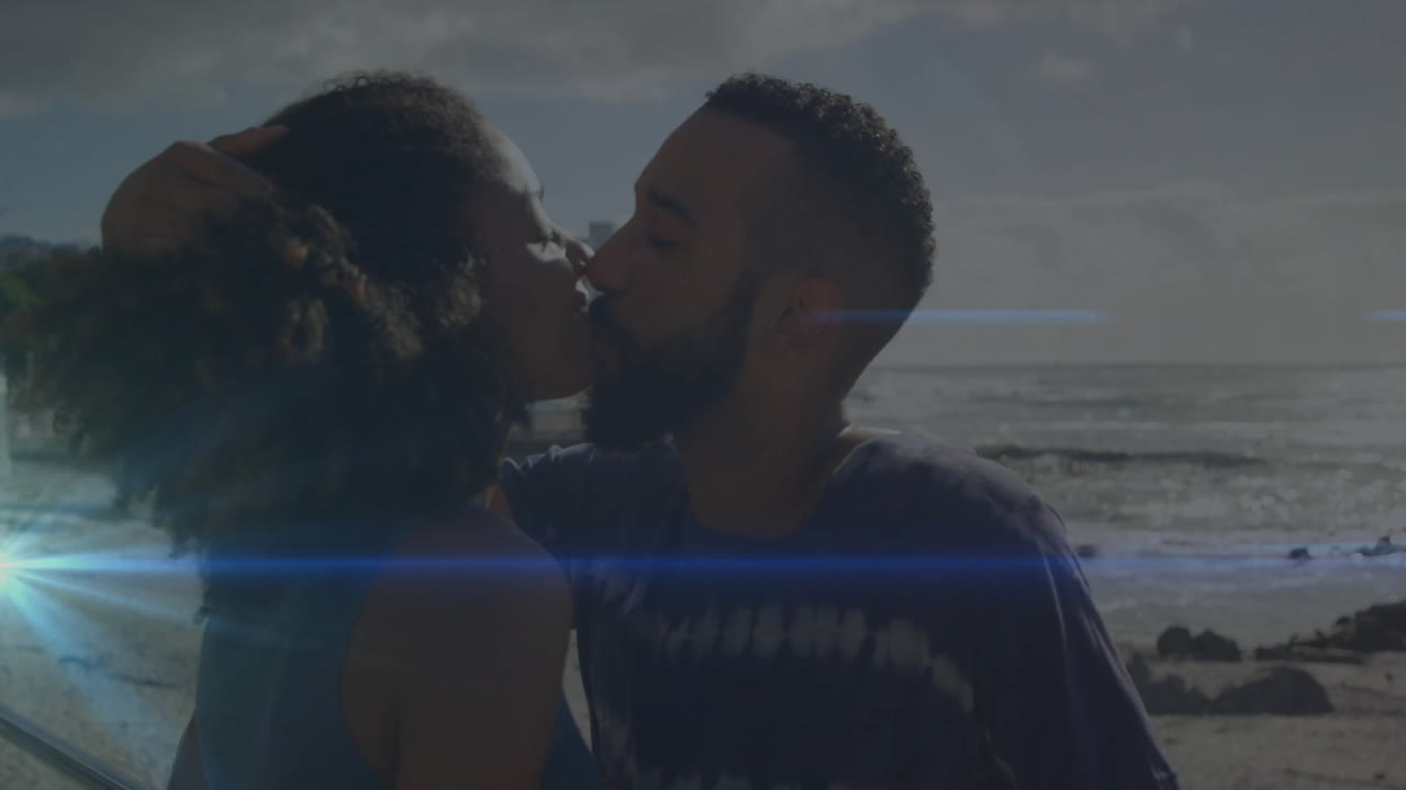 couple sharing kiss on beach in health campaign, with animated sun lens flare and wave icons