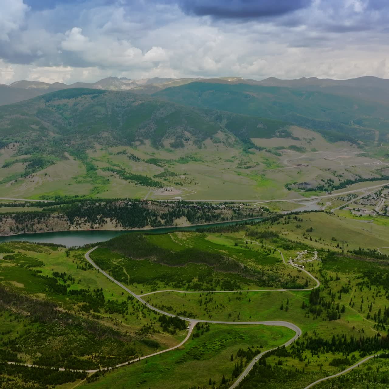 Amazingly beautiful green valleys near the rivers in mountainous region. Little town at the foot of mountain in Colorado. Dramatic sky over the mountain range at backdrop