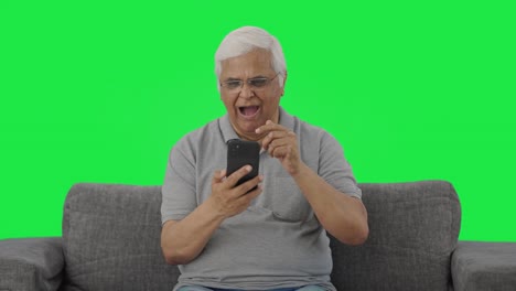 Sleepy-Indian-old-man-scrolling-through-phone-Green-screen