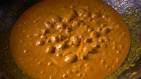 boiling gravy is being removed from the top of the large pan with the sleeve