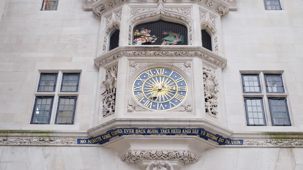 Close-up of a historic clock tower featuring golden Roman numerals and ornate stone carvings in London, England