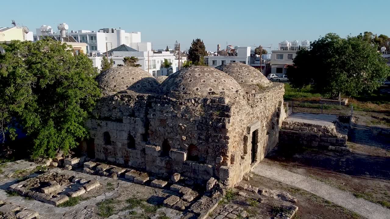 Explore the fascinating ancient ruins featuring unique dome structures surrounded by modern buildings in this lively urban area. Rich history meets contemporary life here