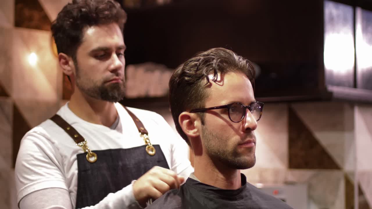 Male barber tying client apron