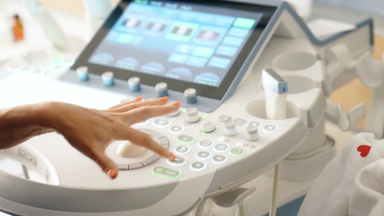 Doctor's hand operating the ultrasound machine. Unrecognized medic performs ultrasonic check up. Close up.