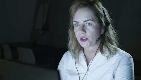 teletrabajador respondiendo a la llamada en una oficina oscura