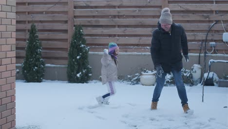 grandfather and granddaughter having fun in the snow