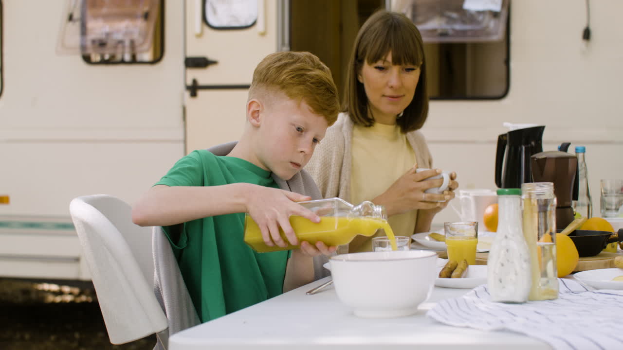familia feliz desayunando en el campamento en el bosque