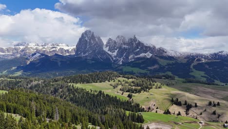 aerial view of alpe di siusi and sassolungo group, showcasing jagged mountains, alpine meadows, and scattered forests in the italian dolomites