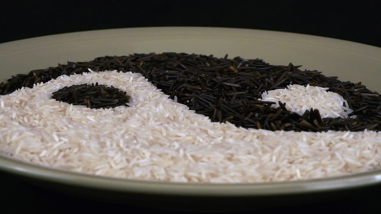 el símbolo yang yin hecho de arroz blanco y negro gira en la placa verde