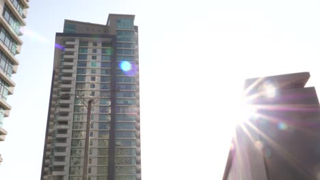 slow dolly left reveal looking up at emaar residential apartments located in crescent bay, karachi with bright sunshine