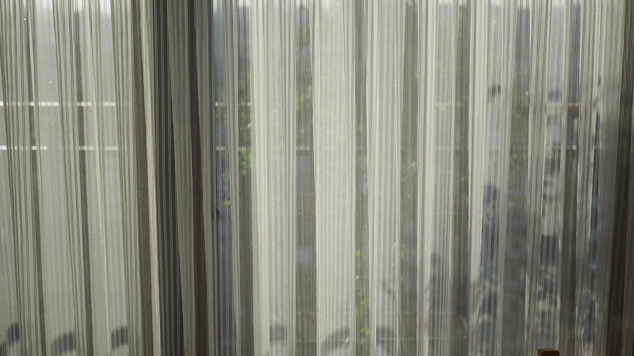 Cortinas blancas transparentes meciéndose suavemente con la brisa