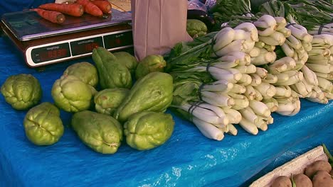 A-vendor-weighing-carrots-at-a-local-organic-farmers-market,-sustainable-and-healthy-lifestyle