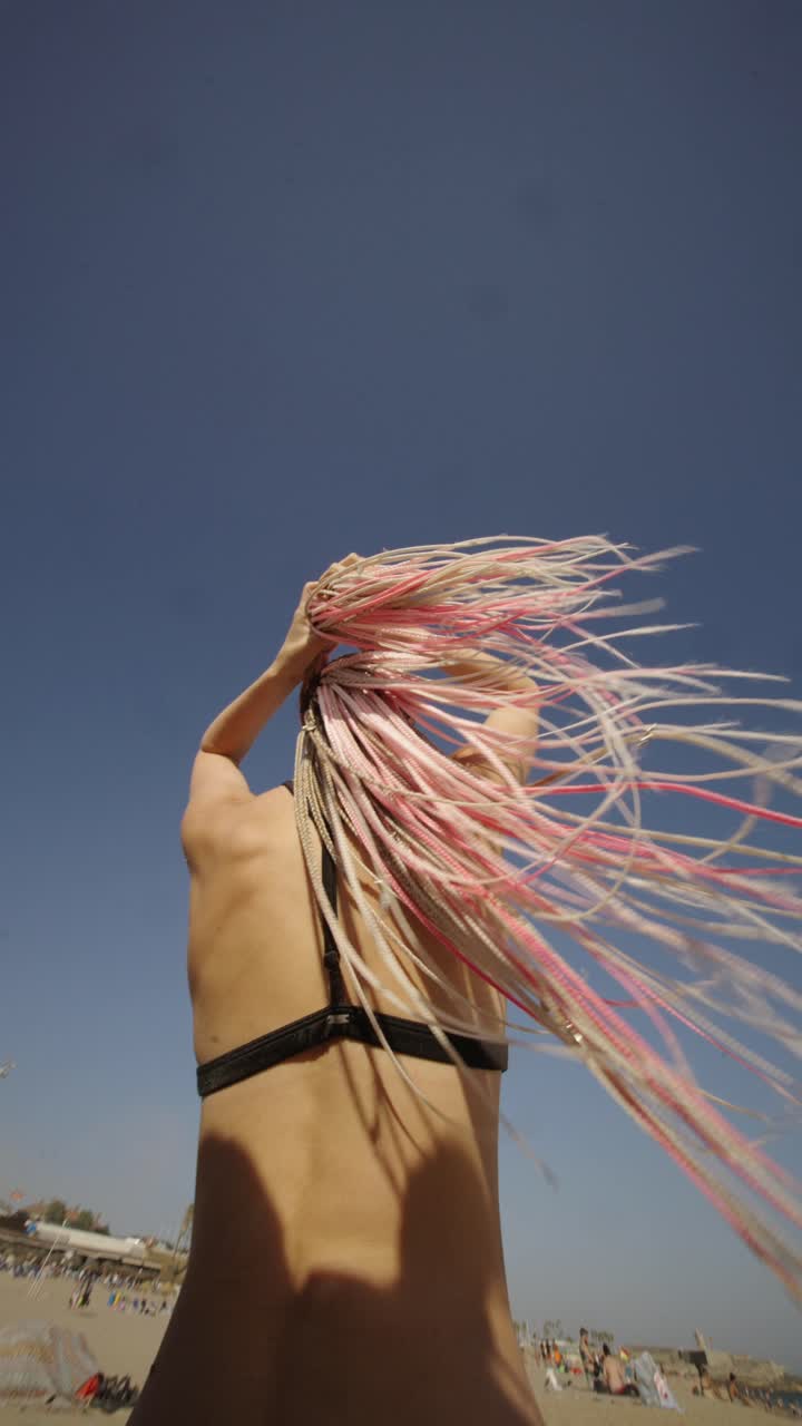 Woman with pink braids under blue sky