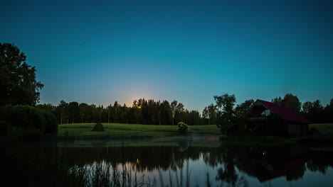 timelapse shot of sunset in the background with the view of a lake in front of a wooden cottage on a foggy evening