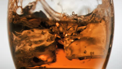 cubos de hielo en súper cámara lenta cayendo en un vaso