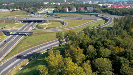 Aéreo:-Intersección-De-Vías-De-Tráfico-Rápido,-Muchas-Bifurcaciones-De-Carreteras-En-Diferentes-Direcciones,-Autos-Y-Camiones-Personales-A-Alta-Velocidad-Que-Se-Dirigen-Hacia-El-Puerto,-Vía-Moderna-De-Tráfico-Rápido