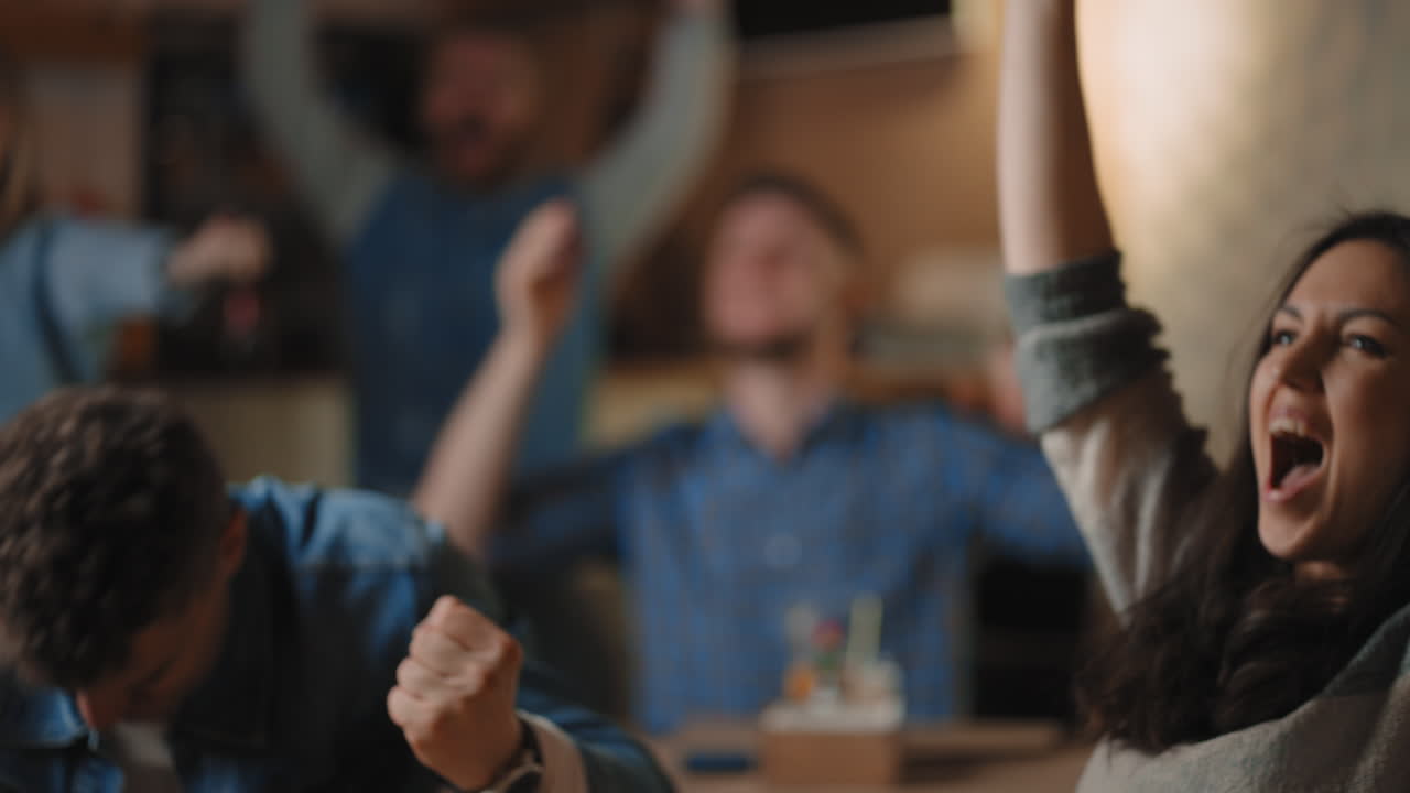 스포츠 팬 들 은 술집 에서 챔피언십 을 시청 하고, 좋아하는 팀 이 승리 한 것 에 대해 행복 하다. 남자 와 여자 친구 들 의 그룹 은 스포츠 바 에서 tv 스크린 에서 경기 를 시청 하는 동안 축하 하는 팬 들