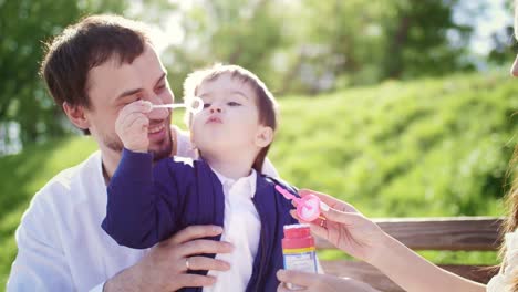 Happy Family Playing Bubbles in Park