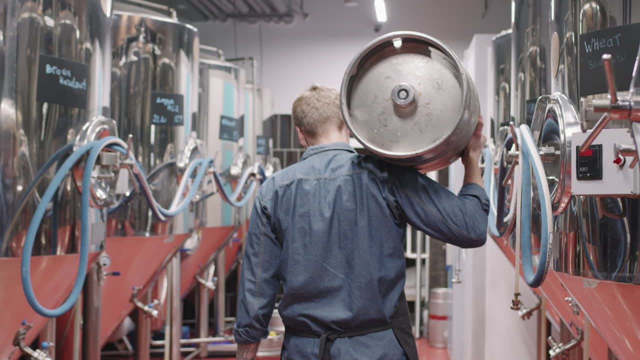 Man Carrying Heavy Beer Keg At Brewery
