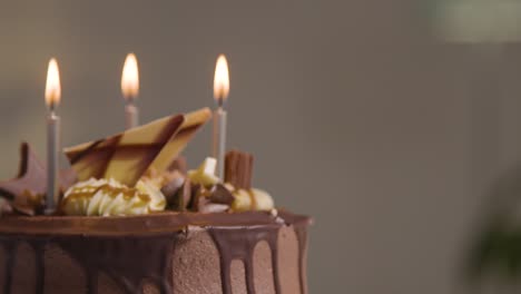 primer plano de pastel de celebración de cumpleaños de chocolate decorado con velas que se apagan en la fiesta en casa 1