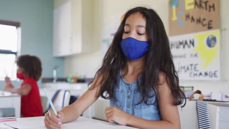 girl wearing face mask sneezing in class at school