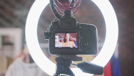 mujer vlogger caucásica haciendo un video de moda en casa
